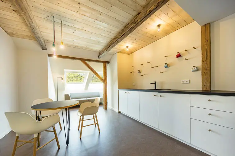 Historische Holzn&auml;gel zum Aufh&auml;ngen von Tassen erinnern an die ehemalige Nutzung als Heuboden