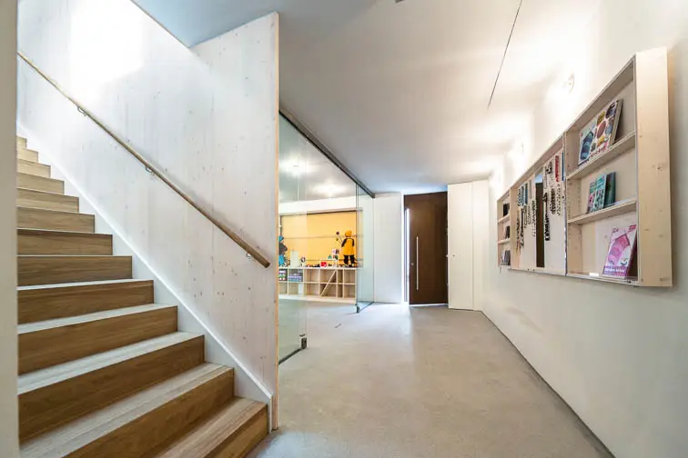 Dreischichtplatten flankieren die Holztreppe